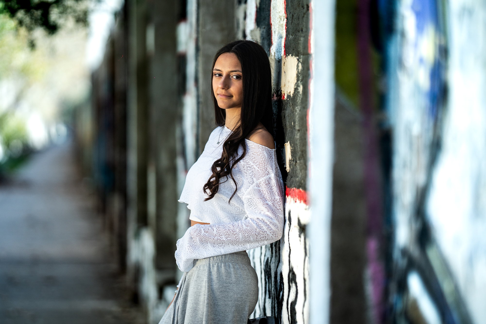 Quinceañera apoyada en una pared con graffiti en Palermo