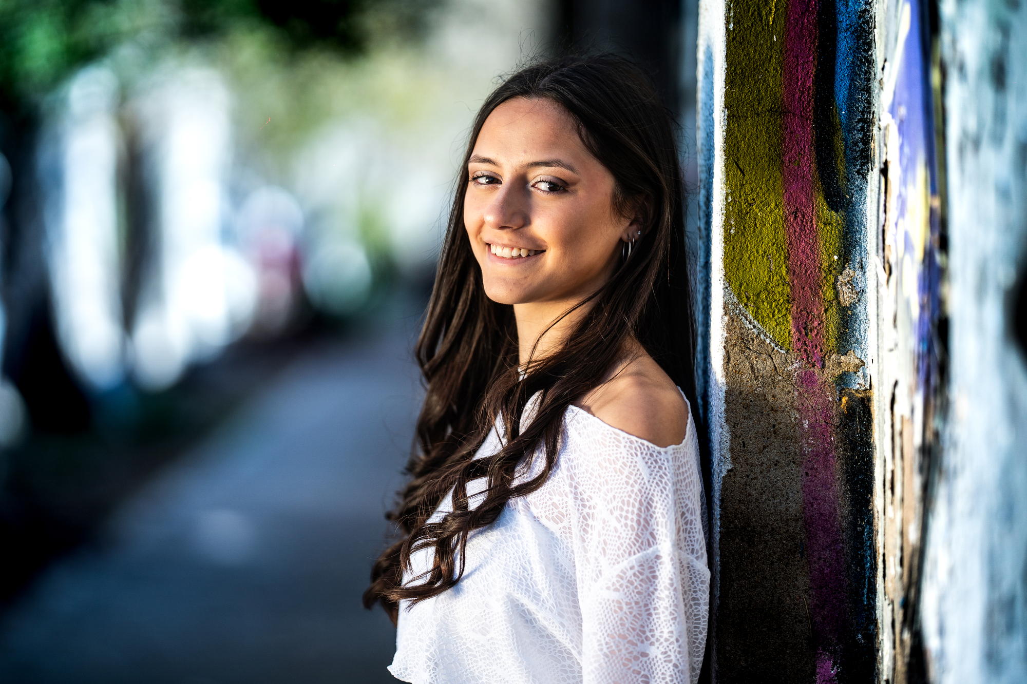 Quinceañera sonriendo apoyada en una pared pintada, Palermo