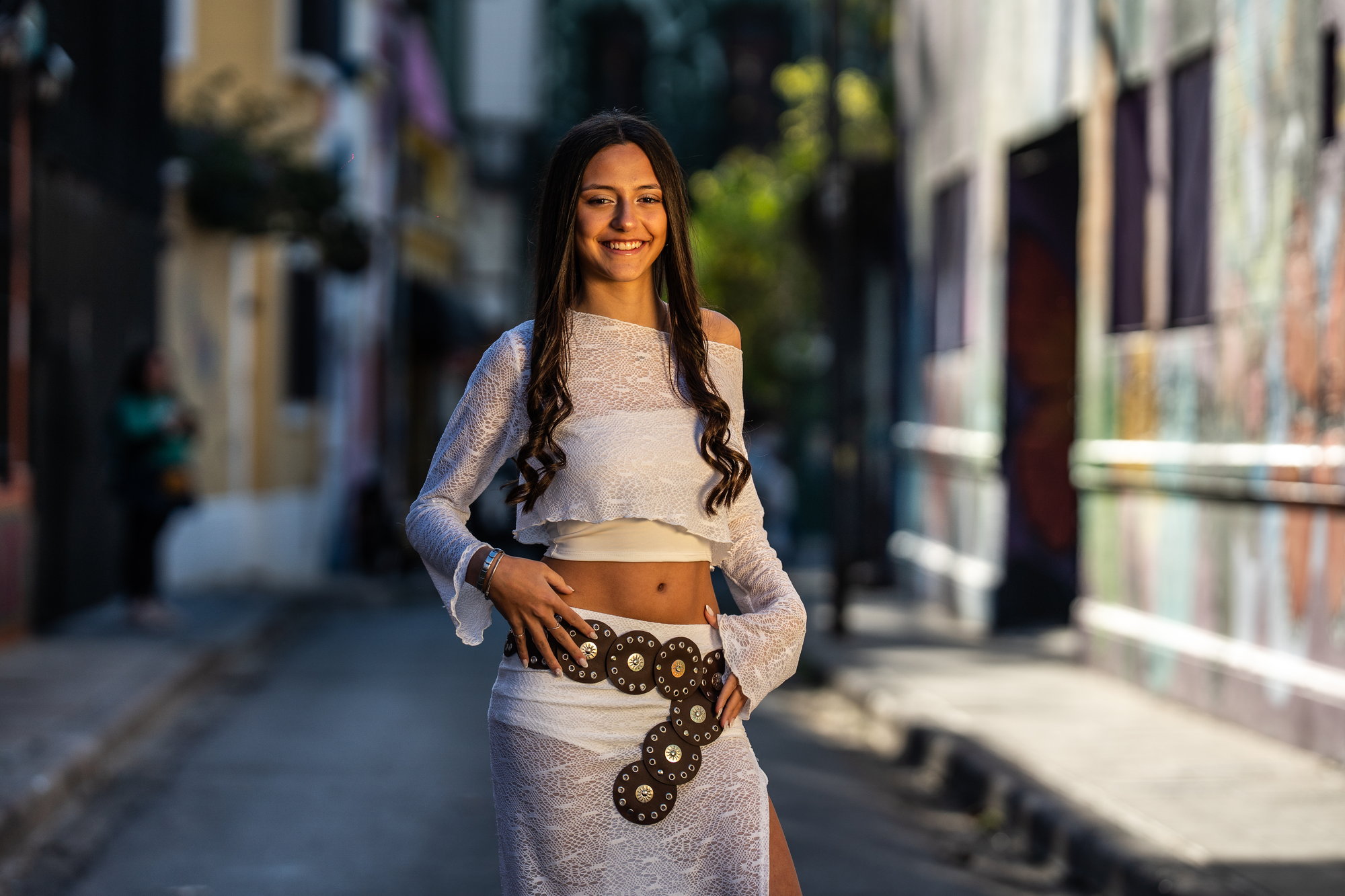 Quinceañera de pie en el medio de una calle empedrada